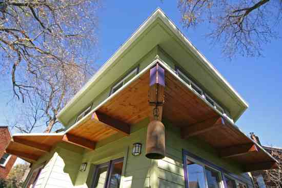 AFTER: The angled addition softened the severe, blocky shape of the existing house. The roof overhangs on the first and second floors provide shading that helps cool the home in summer.